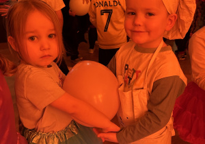 Na zdjęciu dwoje dzieci z balonikiem podczas wykonywania zadania.