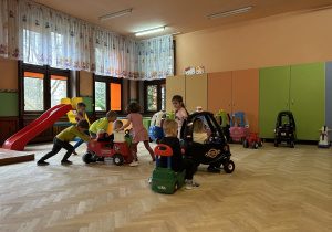 Na zdjęciu dzieci bawią się w samochodzikach na przedszkolnej sali zabaw.