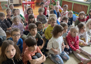 Dzieci siedzące na dywanie podczas zajęć