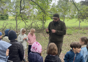 dzieci podczas spaceru ścieżką edukacyjną wraz z przewodnikiem