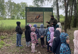 dzieci podczas spaceru ścieżką edukacyjną wraz z przewodnikiem