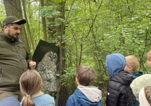 dzieci podczas spaceru ścieżką edukacyjną wraz z przewodnikiem