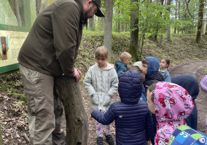 dzieci podczas spaceru ścieżką edukacyjną wraz z przewodnikiem