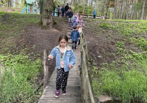 dzieci przechodzące przez drewniany mostek