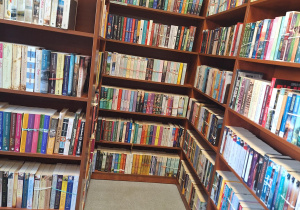 Na zdjęciu znajdują się regały z książkami w bibliotece.