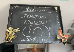 Na zdjęciu czarna tablica przed wejściem na widownię z napisem biała kredą " dzisiaj gramy: Doktor Nieboli"