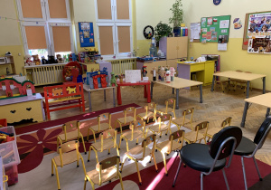 Na zdjęciu: ustawione małe , ponumerowane krzesełka, jak na widowni w teatrze, stolik na którym stoi teatrzyk kukiełkowy, drugi stolik z napisem KASA, trzeci stolik, na którym stoją pacynki