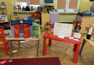 Na zdjęciu : dwa stoliki, na pierwszym mały teatrzyk na drugim kartonik z napisem "Kasa biletowa" i prawdziwe bilety do teatru