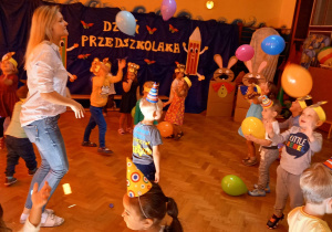 zdjęcie przedstawia dzieci podczas zabawy balonami