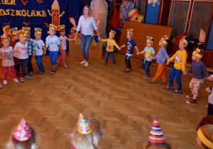 Na zdjeciu dzieci z grupy pierwszej oraz drugiej podczas zabawy w kole z nauczycielką