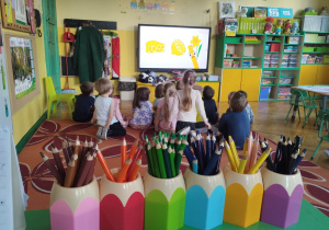Przedszkolaki oglądające film edukacyjny o kredkach