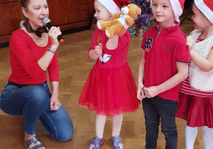 Zdjęcie przedstawia nauczycielkę z trójką dzieci biorących udział w jednym z konkursów.