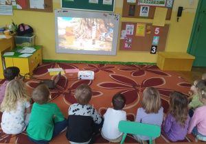 zdjęcie przedstawia dzieci z grupy pszczółek oglądające bajkę o Kubusiu Puchatku
