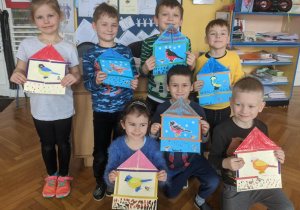 Zdjęcie przedstawia dzieci z grupy VI prezentujące wykonane przez siebie prace plastyczne nt. "Ptasia stołówka"