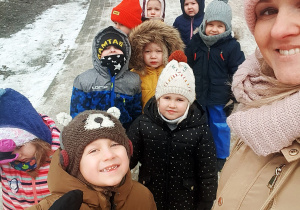 Zdjęcie przedstawia grupę dzieci na spacerze w parku.