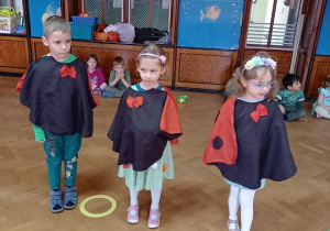 Troje dzieci przebranych w stroje biedroneczek.
