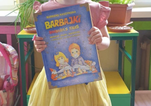 Laureatka konkursu z grupy trzeciej prezentuje otrzymaną nagrodę w postaci książki