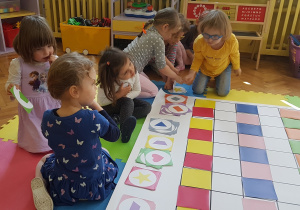 Dziewczynki segregują kartoniki z figurami