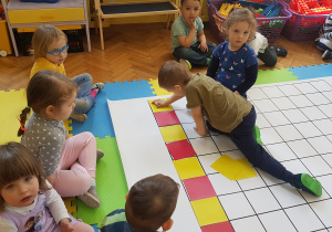 Dzieci układają rytm z kolorowych kartoników na macie do kodowania