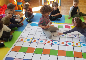 Dzieci układają rytm z kolorowych kartoników na macie do kodowania
