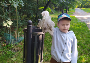 Chłopiec wrzucający śmieć do kosza