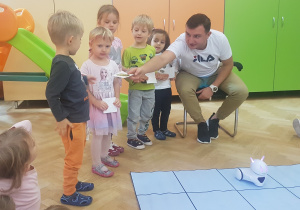 dzieci uczestniczą w zabawie z robotem Photon i specjalną matą do kodowania