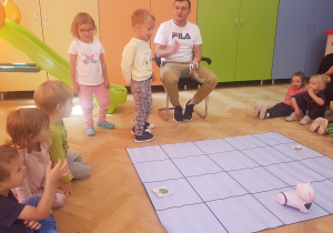 dzieci uczestniczą w zabawie z robotem Photon i specjalną matą do kodowania