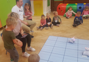 dzieci uczestniczą w zabawie z robotem Photon i specjalną matą do kodowania