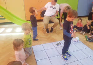 dzieci uczestniczą w zabawie z robotem Photon i specjalną matą do kodowania