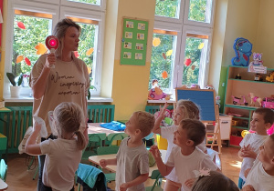 Zdjęcie przedstawia dzieci w czasie zabawy ruchowej "Czerwone i zielone"