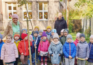Dzieci z grupy trzeciej "Misie" wraz z nauczycielką i Panem Maciejem pozują na tle zasadzonego grupowego drzewa