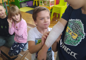 Dzieci podczas prób wykonywania opatrunku