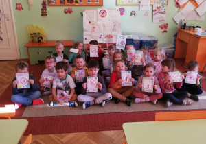 dzieci pokazują swoje rysunki ze znaczkami "zakaz palenia"