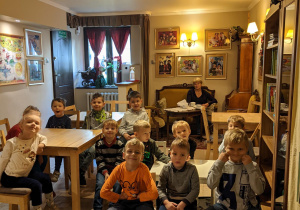 Na zdjęciu widać uśmiechnięte dzieci z grupy VI, siedzące na widowni w Baśniowej Kawiarence i czekające na rozpoczęcie przedstawienia pt. "Śpiąca królewna"