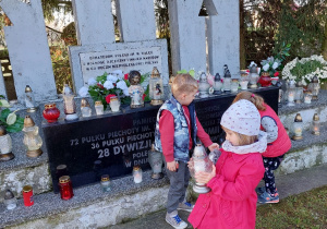 na zdjęciu dziewczynka trzymająca znicz