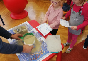 dzieci ozdabiają " złotym" piaskiem soje prace