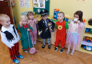 Zdjęcie przedstawia sześcioro dzieci w karnawałowych strojach wrzucających monety do puszki Wielkiej Orkiestry Świątecznej Pomocy.