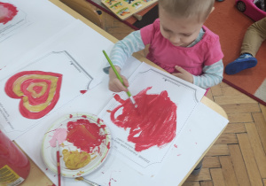dziewczynka malująca serce farbami