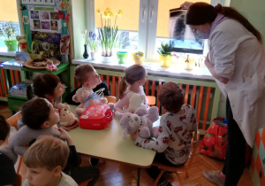 grupa dzieci ogląda zdjęcie rtg płuc, które pod światło pokazuje studentka UM