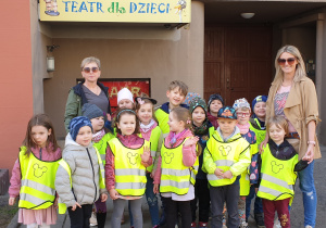 Zdjęcie przedstawia grupę III wraz z nauczycielkami przed wejściem do Baśniowej Kawiarenki