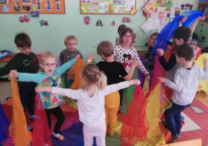 dzieci podczas zabaw muzyczno-ruchowych z wykorzystaniem kolorowych apaszek i chusty animacyjnej