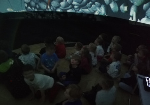 Dzieci oglądające film wewnątrz kopuły kina sferycznego