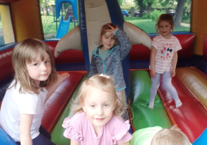 Na zdjęciu dzieci bawią się na dmuchanej trampolinie.