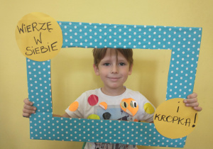 Chłopiec w koszulce w kropki pozuje w ramce
