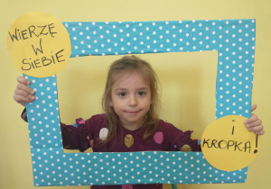 Dziewczynka we fioletowej koszulce pozuje w ramce