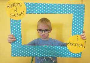 Chłopiec w okularach pozuje w ramce