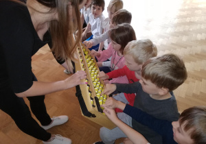 Dzieci oglądają i przesuwają koraliki na japońskim liczydle