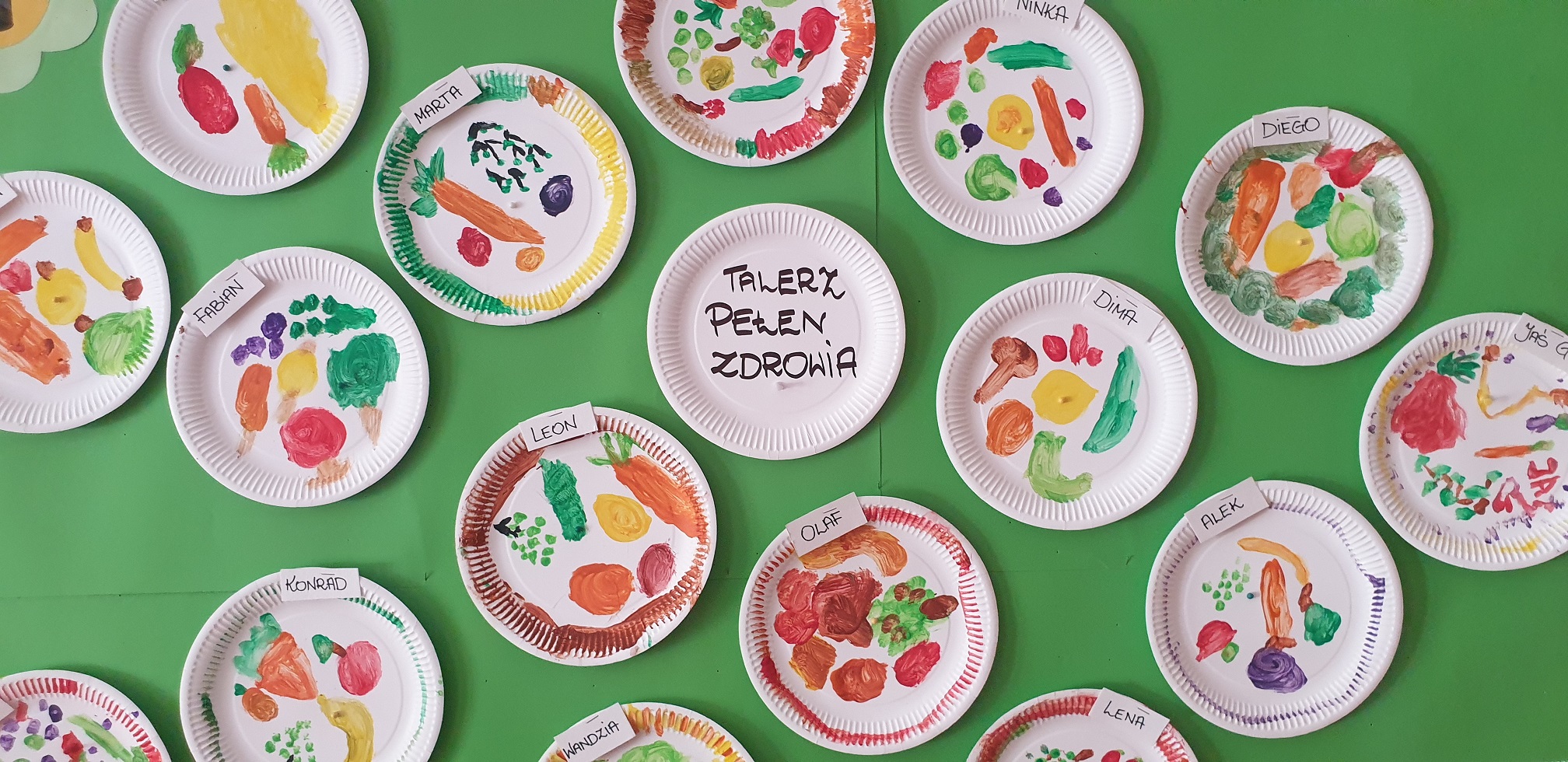 Zdjęcie przedstawia prace plastyczne dzieci - papierowe talerzyki z namalowanymi farbami owocami i warzywami.