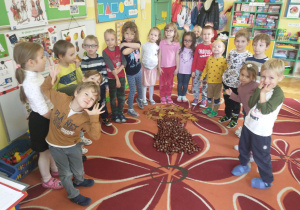 Zajączki pozują przy drzewie z kasztanów i liści
