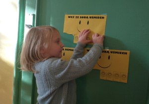 Dziewczynka zrywa karteczkę z uśmiechem
